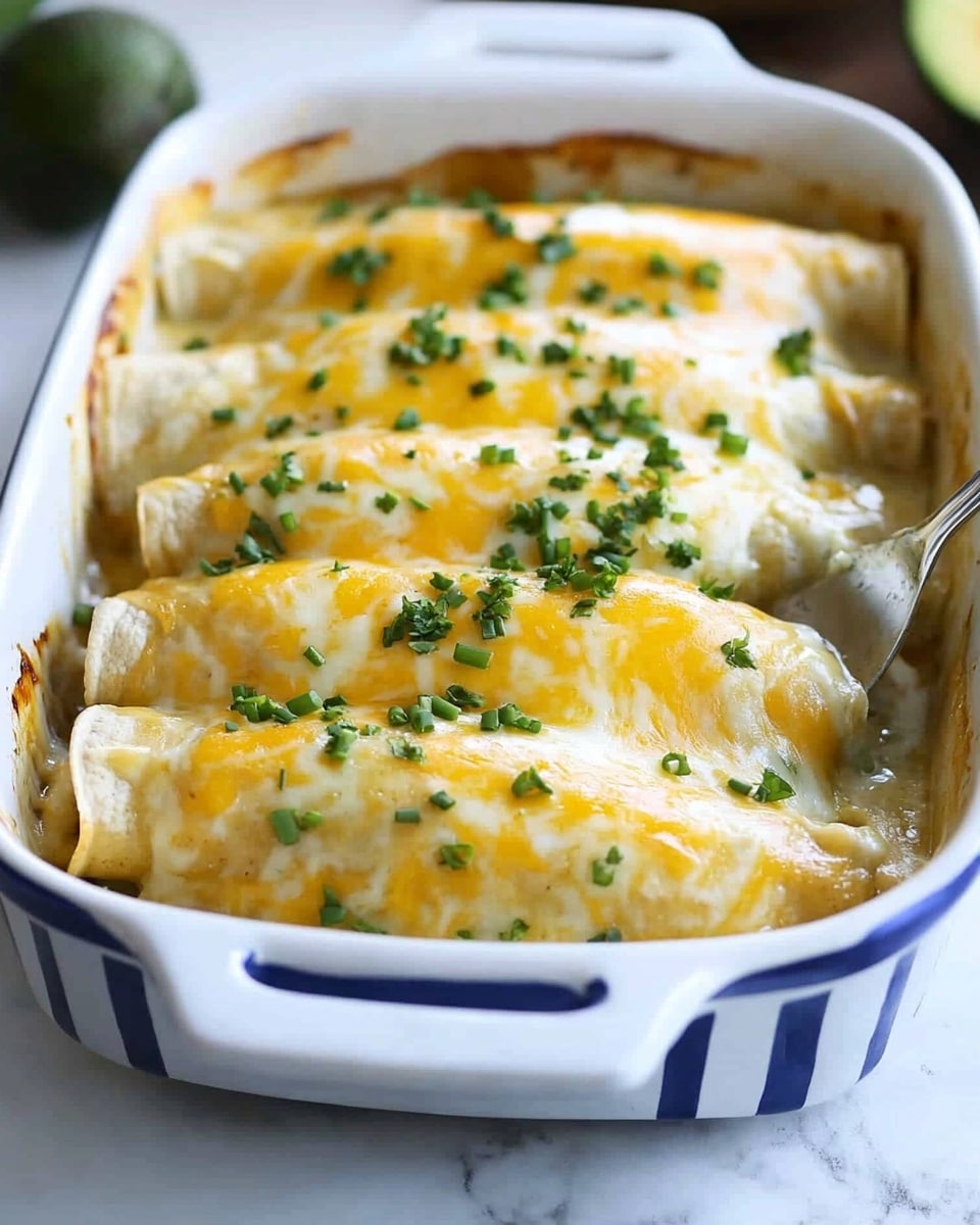 A white ceramic baking dish with blue stripes holds four enchiladas lined up side by side. Each enchilada is covered with a thick layer of melted white and yellow cheese that is stringy and oozing slightly as one enchilada is lifted by a spatula. Small green pieces of chopped onion or chives are sprinkled on top, adding a fresh touch. The surface under the baking dish has a white marbled texture. In the blurred background, there is a halved avocado and some greens. photo taken with an iphone --ar 4:5 --v 6.1