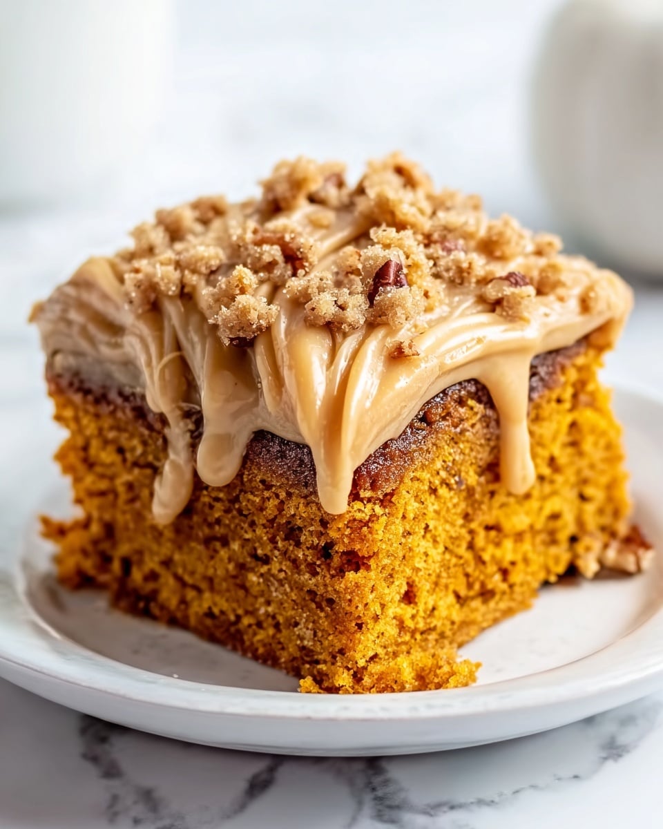 A square piece of pumpkin cake with two layers sits on a white plate. The bottom layer is a dense, moist orange pumpkin cake. The top layer is a thick creamy light tan frosting with small bits of pecans sprinkled on top. A rich caramel sauce slowly drips down the sides of the cake, pooling slightly on the plate. The background is a white marbled surface with two small pumpkins blurred in the back. Photo taken with an iphone --ar 4:5 --v 7