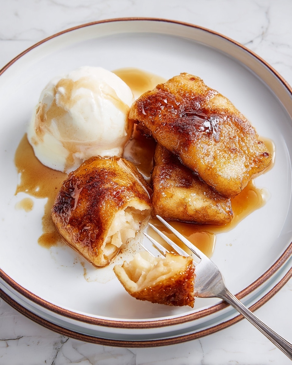 A white plate with a thin brown edge holds three golden brown, crispy fried pieces of food arranged on the right side with a rich brown sauce pooling underneath and around them. On the left side, there is a round scoop of white ice cream with a light drizzle of the same brown sauce on top. A shiny silver fork is placed at the bottom of the plate, lifting one piece, showing its soft, moist inner texture. The plate sits on a white marbled surface in bright natural light. Photo taken with an iphone --ar 4:5 --v 7