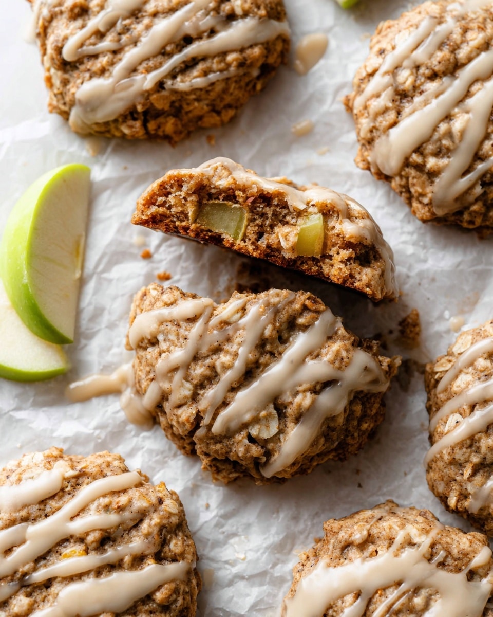 A white plate with a scalloped edge holds eight oatmeal cookies topped with a light beige glaze drizzled unevenly across each cookie. The cookies have a rough, crumbly texture with visible oats and nuts, showing a mix of light brown and golden tones. The plate is placed on a white marbled surface with a green cloth partially visible in the lower left corner. A speckled beige ceramic cup filled with a light brown drink is seen in the upper left corner. The lighting softly highlights the textures and warm colors. photo taken with an iphone --ar 4:5 --v 7