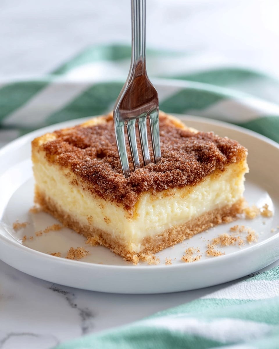 The image shows three stacked square pieces of dessert on a white marbled surface. Each piece has three layers: a light brown, crisp base at the bottom, a thick middle layer of creamy pale yellow filling, and a top layer covered with a generous sprinkle of brown cinnamon sugar crystals. The edges of the top layer appear slightly crunchy and textured, with some sugar granules visible. The dessert looks soft and rich inside with a sugary, crunchy top. Photo taken with an iphone --ar 4:5 --v 7