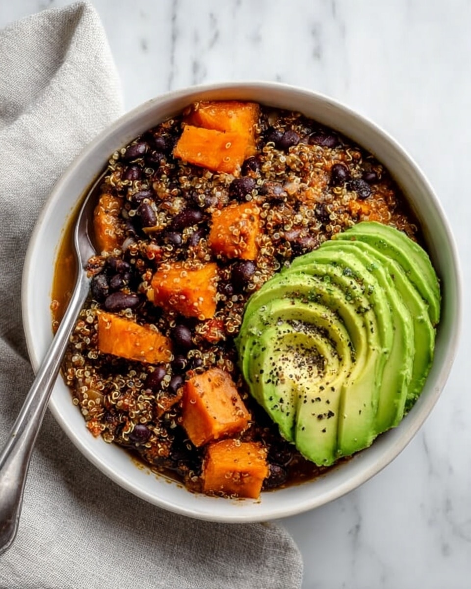 The image shows three white bowls filled with a colorful quinoa dish placed on a white marbled surface. Each bowl has a base layer of quinoa mixed with black beans and orange chunks of cooked squash or sweet potato. On top, there are slices of green avocado arranged neatly on one side. A dollop of creamy white sauce with a smooth texture is placed in the center, sprinkled with chopped green herbs. Thin strips of pale yellow cheese are scattered over the dish, adding a light contrast. In the front bowl, a silver spoon is resting inside, standing vertically. Near the bowls, there is a small white bowl with a creamy sauce and a spoon inside, and some fresh green herb leaves are scattered on the surface. Photo taken with an iphone --ar 4:5 --v 7