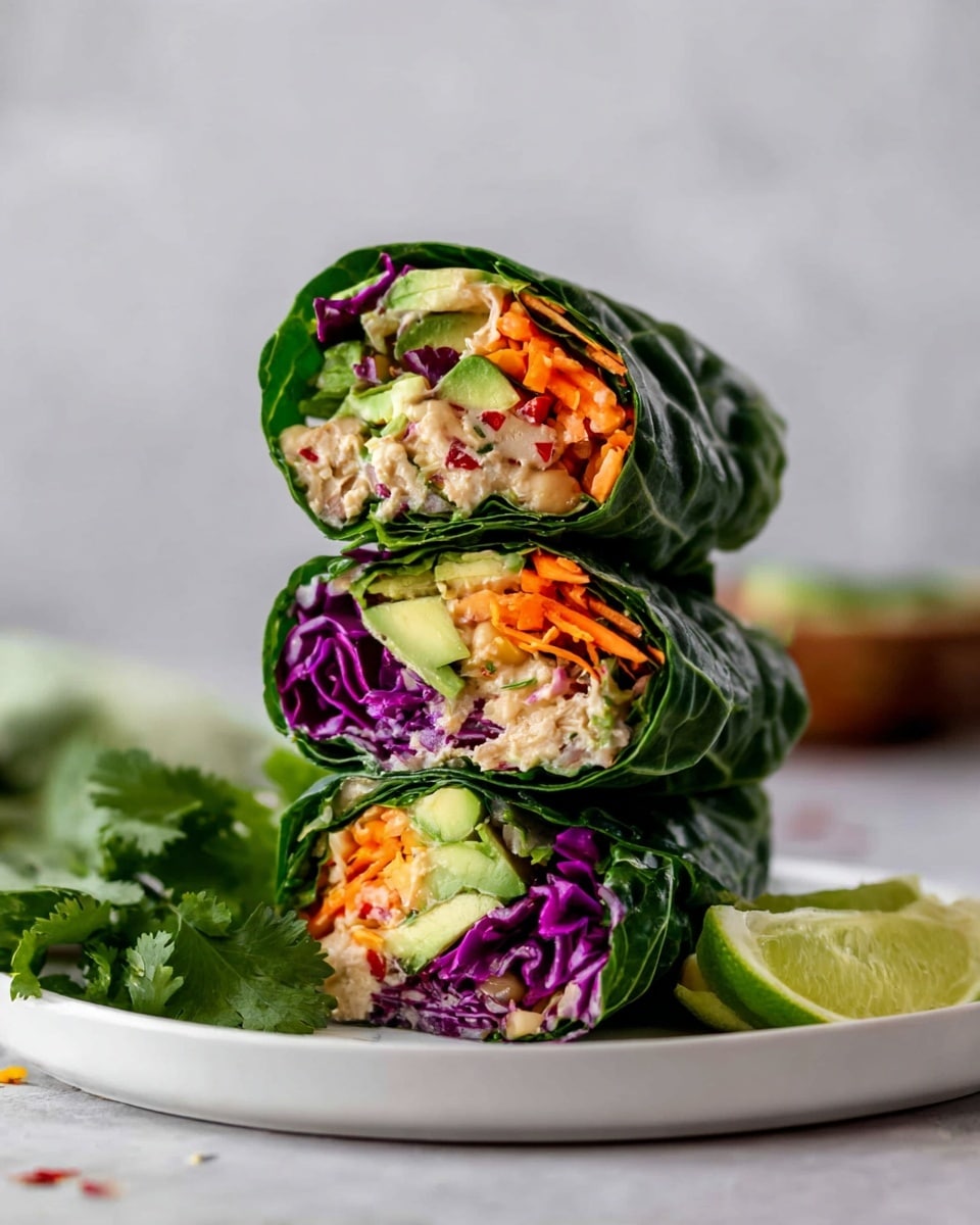 The image shows three wraps stacked vertically on a white plate with lime wedges on the side, placed on a white marbled surface. Each wrap has layers starting with a green leafy outer layer, then a vibrant mix of orange shredded carrots, purple cabbage, chunks of bright green avocado, and a beige filling that looks like shredded chicken or tuna. Fresh green cilantro leaves are partially visible near the plate, adding a fresh touch. The colors are bright and fresh, making the wraps look healthy and tasty. photo taken with an iphone --ar 4:5 --v 7