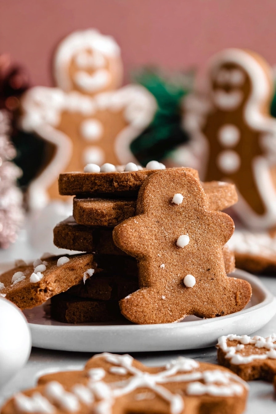 The image shows a close-up of a stack of three brown gingerbread cookies, each with a soft and crumbly texture, and white icing dots on top. Around the stack, there are several more gingerbread cookies in different shapes, also decorated with white icing. In the background, there are blurred gingerbread people cookies with white icing details, standing upright. The scene includes a small white ornament ball in the foreground, and everything is set on a white marbled surface. Photo taken with an iphone --ar 4:5 --v 7
