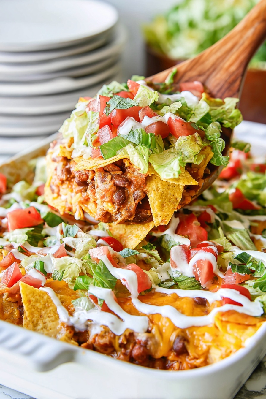 A white oval dish filled with layers of food starting with cooked chicken pieces in a red sauce at the bottom, topped with a thick layer of golden crushed tortilla chips, followed by fresh chopped green lettuce mixed with small, bright red tomato pieces, and finished with diagonal, smooth white sauce lines drizzled evenly across the top, all placed on a white marbled surface photo taken with an iphone --ar 4:5 --v 7