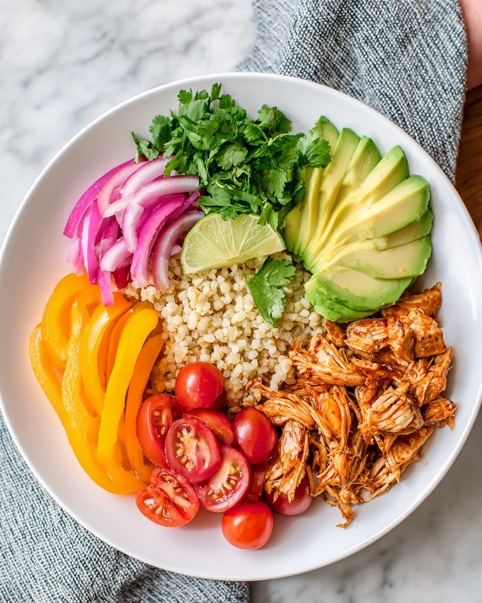 A white plate holds a colorful meal arranged in layers. The bottom layer is light brown cooked cauliflower rice covering the center. On the right, shredded orange-brown cooked chicken sits over the rice. On the top center, there are several pale green slices of avocado neatly placed. Pink pickled onions are stacked next to the avocado on the upper left side. Fresh green cilantro leaves sit next to a small wedge of light green lime on the far left. Below the cilantro, bright yellow bell pepper strips are arranged, and at the bottom, halved small red cherry tomatoes fill the space. All this is on a white marbled surface with a woman's hand partially visible above the plate. Photo taken with an iphone --ar 4:5 --v 7