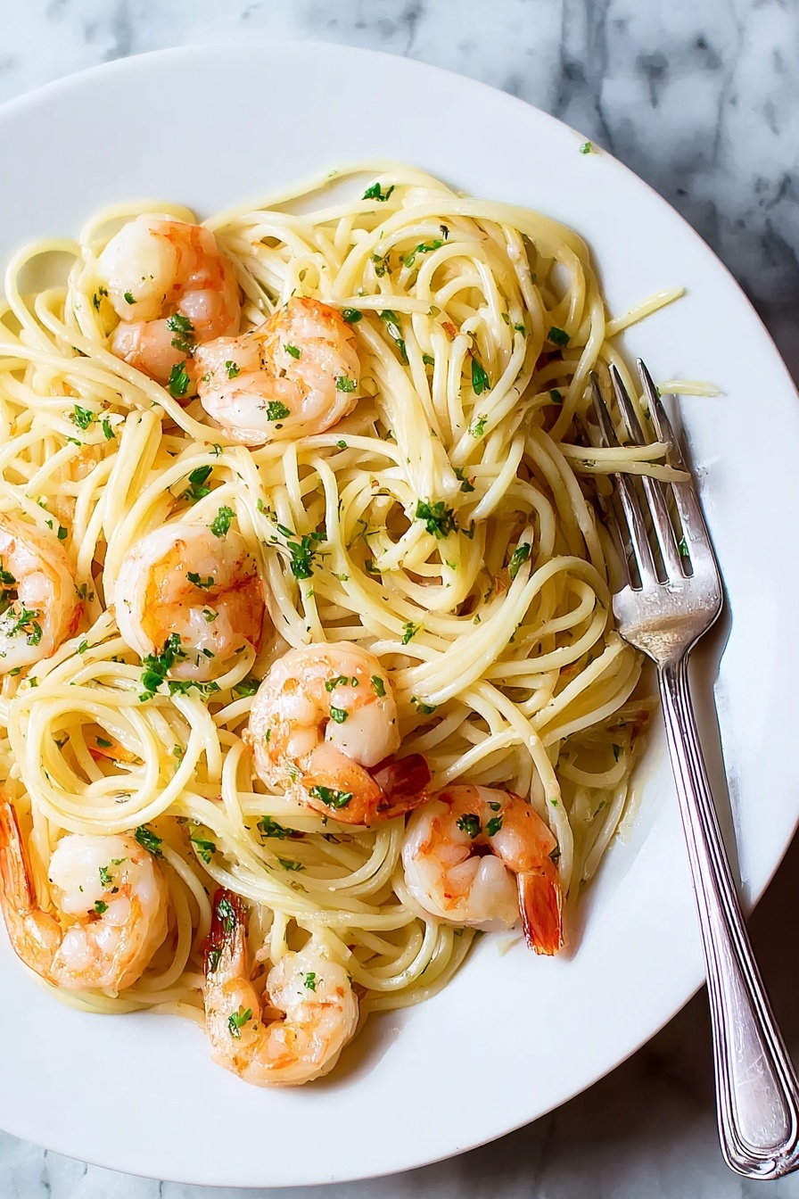 A white plate holds a serving of spaghetti pasta layered with several pink shrimp scattered evenly on top and mixed throughout. The shrimp have a light cooked texture with firm orange tails. The pasta is light yellow and shining lightly, coated with small bits of green herbs sprinkled all over. A silver fork rests on the right edge of the plate. The background is a white marbled surface. Photo taken with an iphone --ar 4:5 --v 7