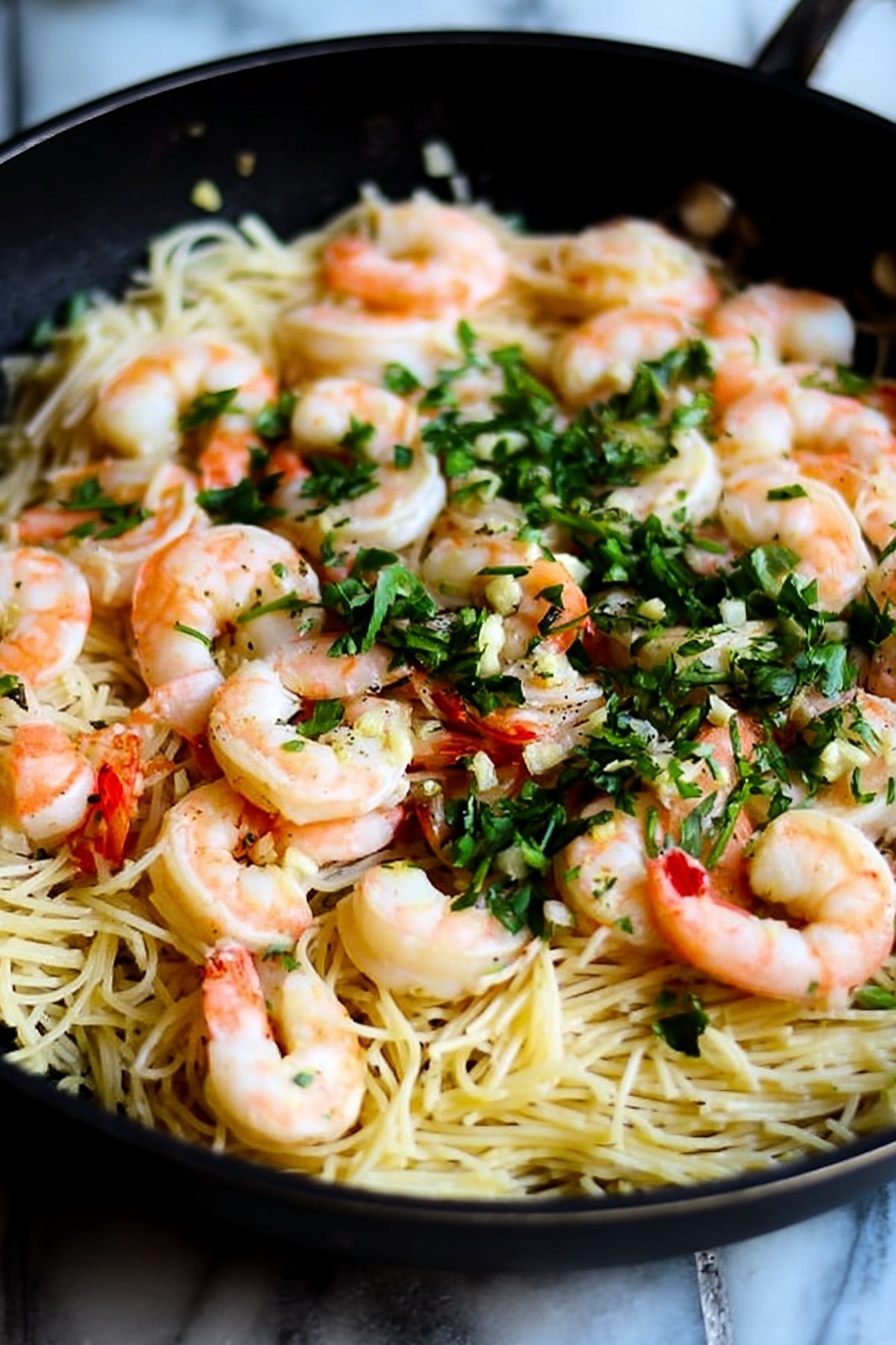 A close-up view of a black skillet filled with a bed of thin, light yellow noodles layered with several pink and white cooked shrimp placed evenly on top. Bright green chopped herbs are sprinkled throughout the dish, adding a fresh pop of color. Small pieces of garlic can be seen around the edges, and the texture of the noodles looks soft and slightly glossy. The background is a white marbled surface. photo taken with an iphone --ar 4:5 --v 7