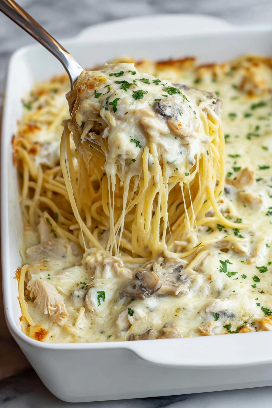 A white rectangular baking dish filled with a layered baked pasta dish that has a top layer of creamy white melted cheese sprinkled evenly with small green parsley bits. Underneath the cheese, pale yellow pasta strands and bits of light brown mushrooms are visible. The baking dish is placed on a wooden surface. The edges of the cheese top have slight browning and bubbling that show it has been baked. Photo taken with an iphone --ar 4:5 --v 7