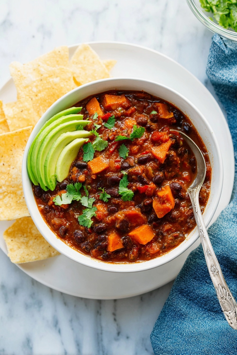 A white pot filled with thick, dark brown chili containing visible chunks of black beans, pinto beans, and small pieces of orange carrots and red bell peppers. The chili has a rich, smooth texture with hints of fresh green herbs scattered on top. A wooden spoon is partially dipped into the chili, showing the mix of colors and ingredients. The pot sits on a white marbled surface with some chili stains around the edges. Photo taken with an iphone --ar 4:5 --v 7