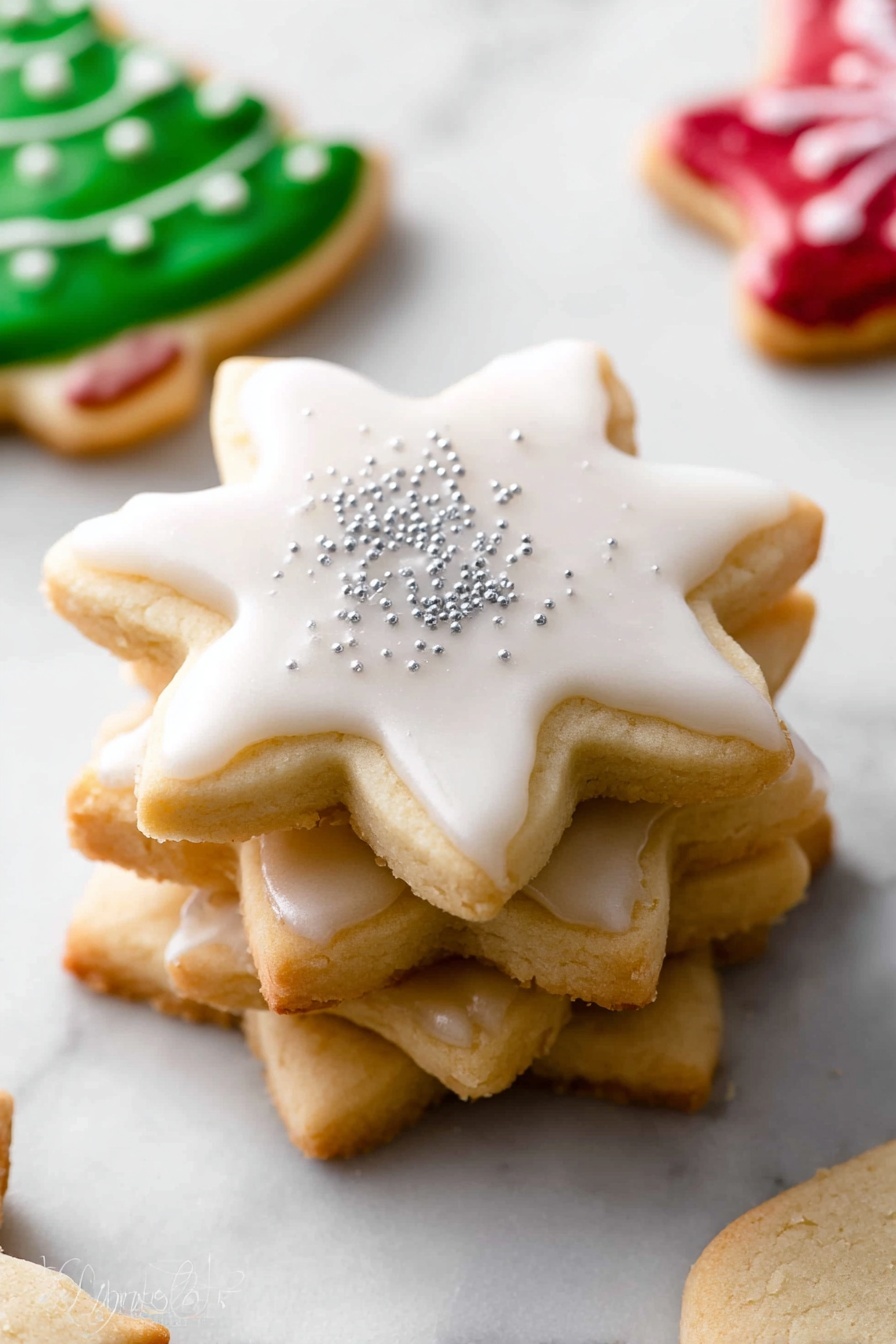 The image shows a stack of five star-shaped cookies on a white marbled surface. The top cookie is decorated with smooth white icing that covers the whole surface and is sprinkled with small silver sugar crystals. The cookies below are plain with a light golden-brown color and slightly textured edges. Around the stack, there are other cookies partially visible: one decorated with green icing and white dots, another with red icing, and others with white and red decorations. photo taken with an iphone --ar 4:5 --v 7