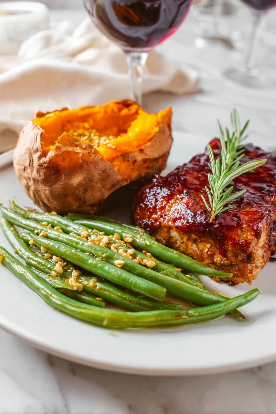 The image shows a white plate with three food items arranged in separate sections. On the right side, there is a thick piece of grilled meat covered with a dark reddish glaze and garnished with a small sprig of green rosemary on top. In the center-left, there is a baked sweet potato, opened to show its bright orange, soft inside. In front of the sweet potato, there is a pile of green beans coated with small mustard seeds and a light sauce, giving them a slightly glossy look. The plate is set on a white marbled surface with blurred background elements including a glass of red wine and white fabric. photo taken with an iphone --ar 2:3 --v 7 - Green Beans with Mustard Butter Sauce, green beans side dish, easy vegetable recipes, quick healthy side dish, flavorful green bean recipe
